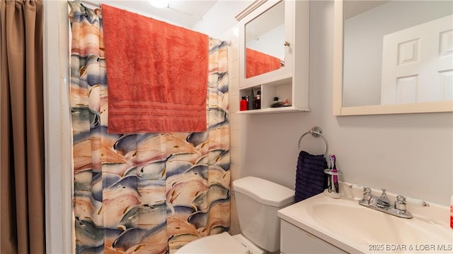 bathroom featuring toilet, curtained shower, and vanity