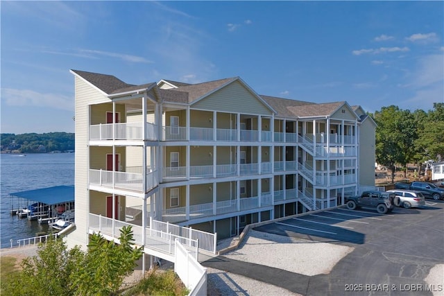 view of building exterior with a water view and uncovered parking