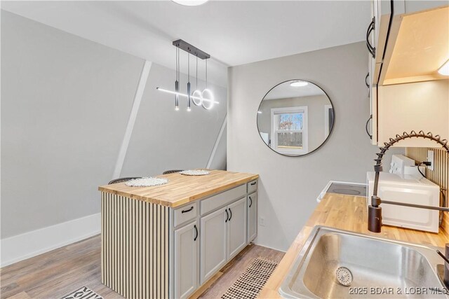 full bathroom featuring double vanity, baseboards, and wood finished floors