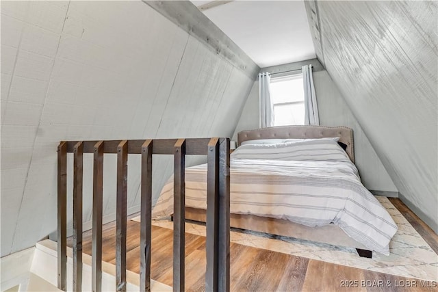 unfurnished bedroom featuring vaulted ceiling and wood finished floors