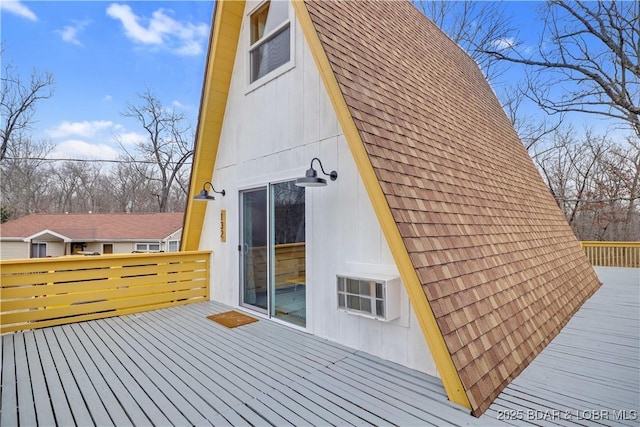 view of property exterior with a shingled roof and a wooden deck