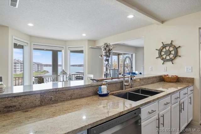 488 Regatta Bay Dr Unit 2C, Lake Ozark, MO 65049 - kitchen featuring stainless steel dishwasher, a textured ceiling, light stone countertops, white cabinetry, and recessed lighting
