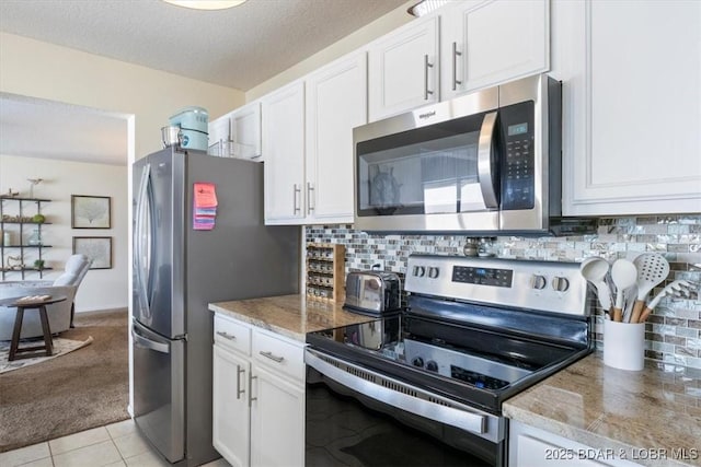 488 Regatta Bay Dr Unit 2C, Lake Ozark, MO 65049 - kitchen with appliances with stainless steel finishes, white cabinets, light carpet, and a textured ceiling