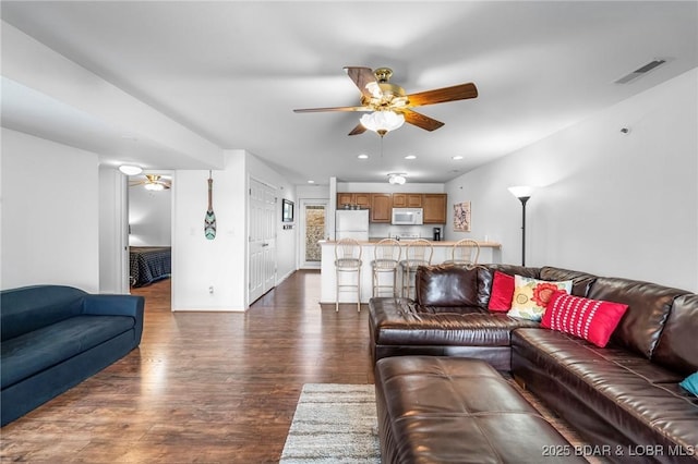 living room with visible vents, a ceiling fan, recessed lighting, baseboards, and dark wood-style flooring