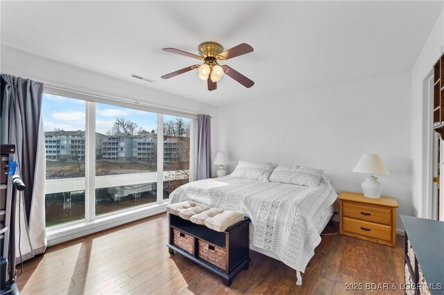 bedroom with visible vents, wood-type flooring, and ceiling fan