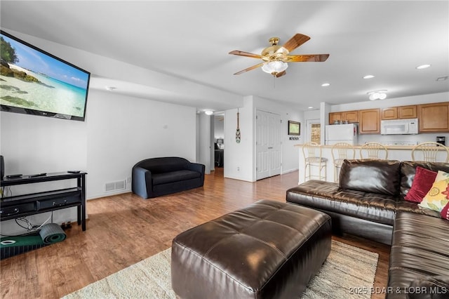 living area featuring visible vents, a ceiling fan, wood finished floors, recessed lighting, and baseboards