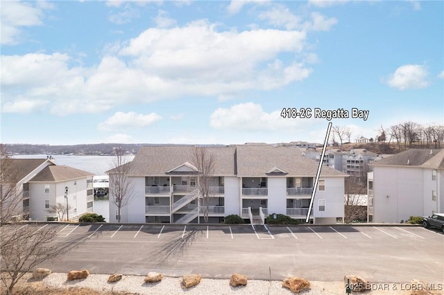 view of building exterior featuring uncovered parking and a residential view