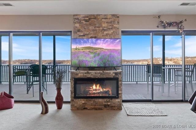 living area featuring a fireplace, carpet flooring, and visible vents