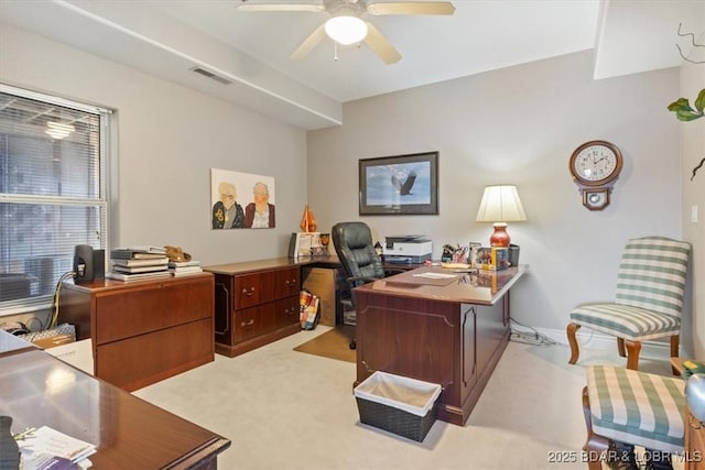 office area with light colored carpet, visible vents, ceiling fan, and baseboards