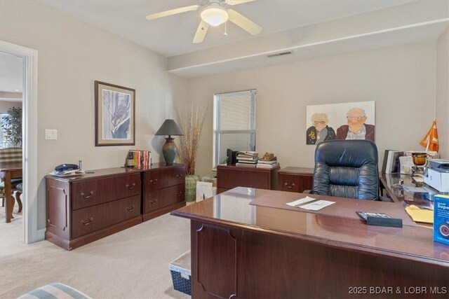 office area featuring ceiling fan, visible vents, and light colored carpet