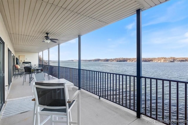 balcony featuring ceiling fan and a water view