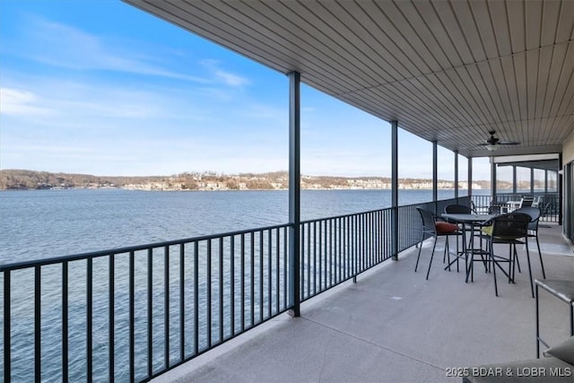 balcony featuring a water view and ceiling fan