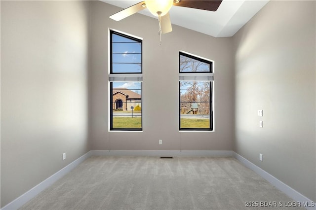 unfurnished room featuring ceiling fan, baseboards, a towering ceiling, and light carpet