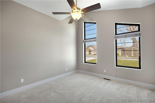 unfurnished room with plenty of natural light, light colored carpet, baseboards, and visible vents