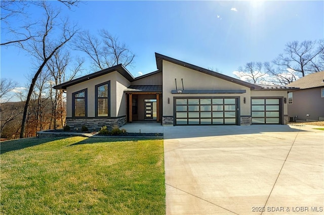 contemporary home with stucco siding, metal roof, stone siding, an attached garage, and a standing seam roof