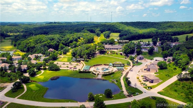 drone / aerial view with a wooded view and a water view