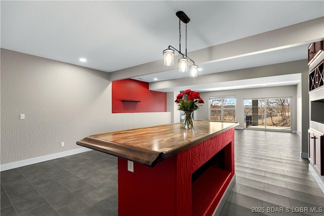 kitchen featuring baseboards, a kitchen island, recessed lighting, pendant lighting, and open floor plan