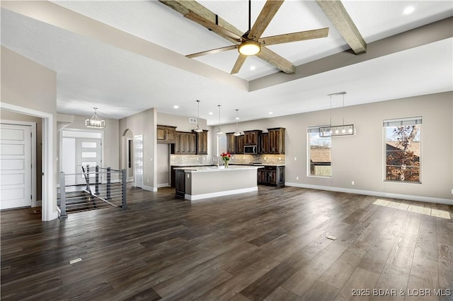 unfurnished living room with recessed lighting, beamed ceiling, baseboards, and dark wood-style floors