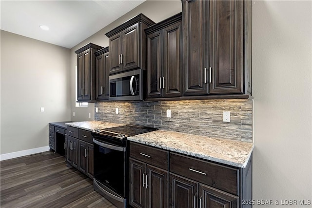 kitchen featuring stainless steel microwave, baseboards, backsplash, and range with electric stovetop