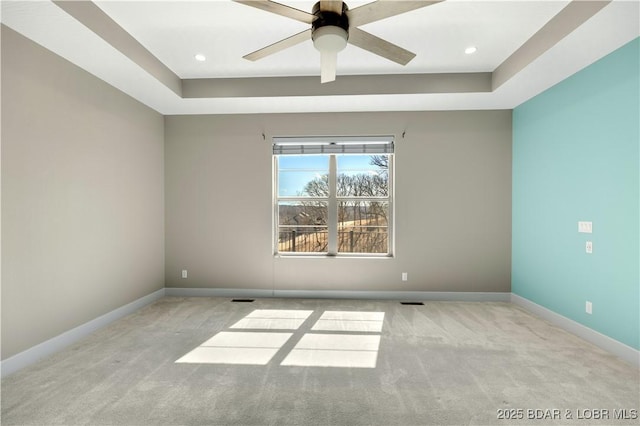 carpeted empty room featuring a ceiling fan, a tray ceiling, recessed lighting, and baseboards