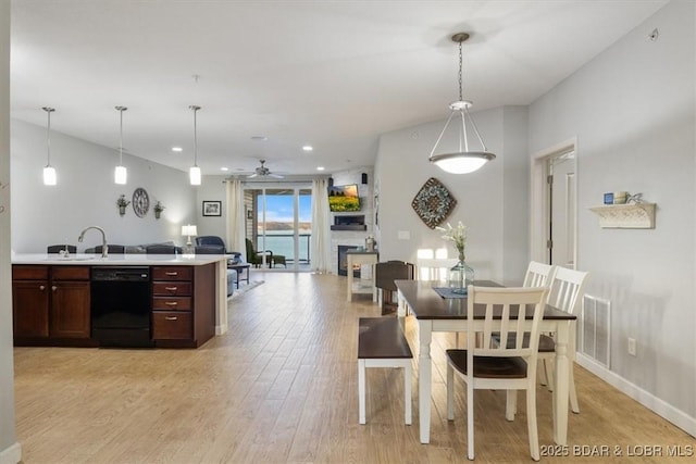 dining area with recessed lighting, a fireplace, visible vents, a ceiling fan, and light wood-type flooring