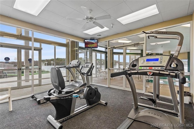 workout area featuring ceiling fan and a paneled ceiling