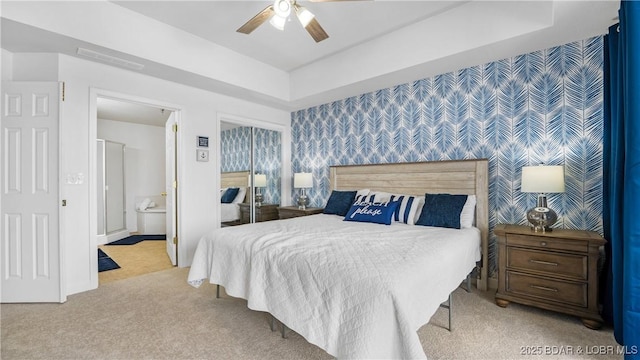 bedroom with a closet, visible vents, carpet flooring, ceiling fan, and wallpapered walls