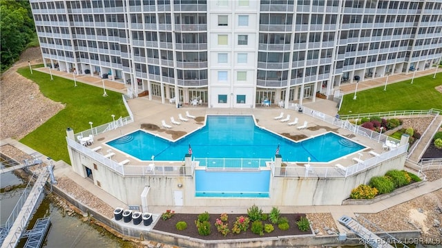 community pool featuring a fenced backyard and a patio