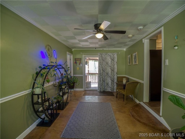 interior space with crown molding, baseboards, and ceiling fan