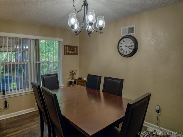 dining area with visible vents, dark wood finished floors, a textured ceiling, and baseboards