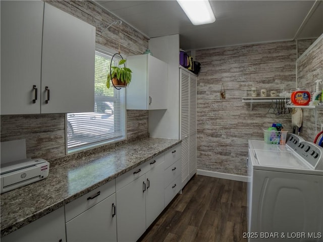 kitchen featuring dark wood-style floors, light stone counters, white cabinets, and washer and dryer