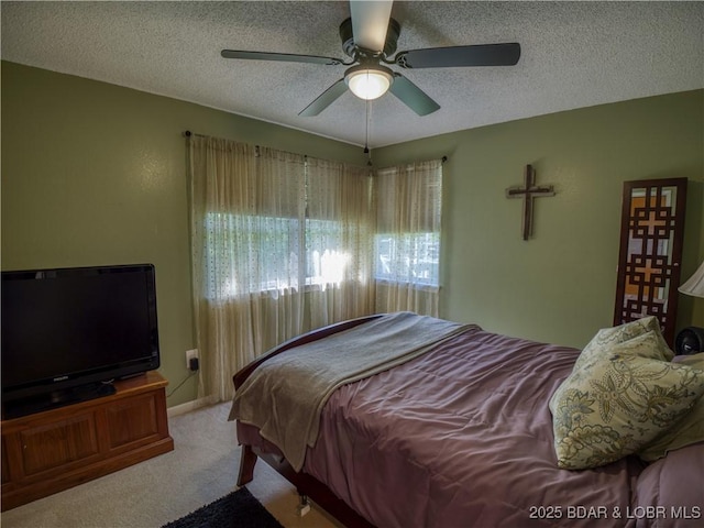 bedroom with a textured ceiling, a ceiling fan, and carpet flooring