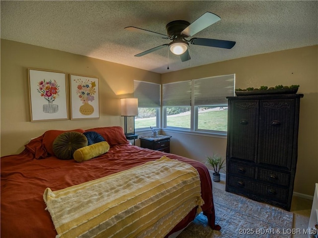 bedroom with ceiling fan and a textured ceiling