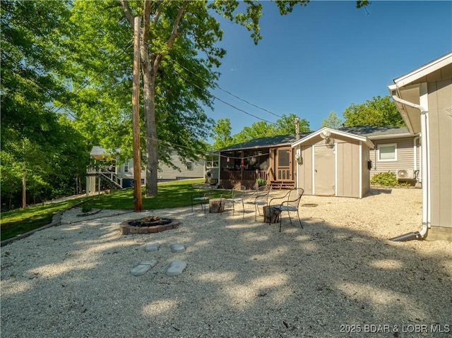 view of yard with a storage shed, an outdoor fire pit, and an outbuilding