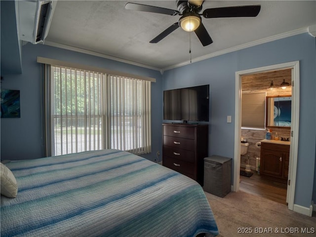 bedroom with ceiling fan, connected bathroom, light colored carpet, and crown molding