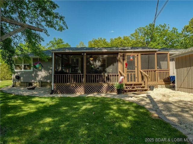 rear view of property with a sunroom and a lawn