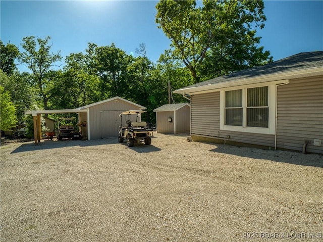 view of yard featuring a carport, an outbuilding, and a storage shed