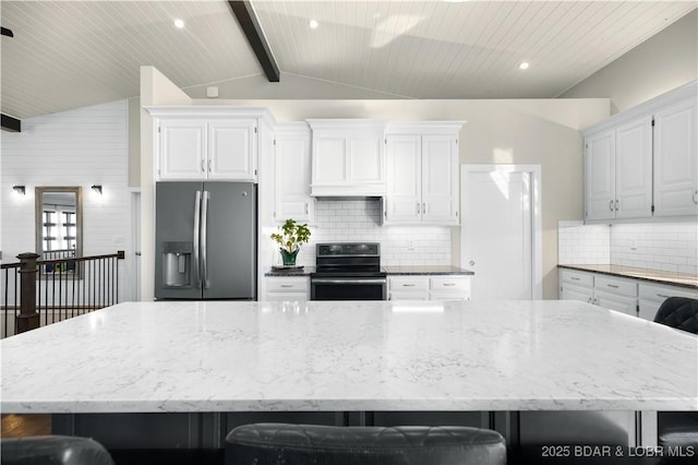 kitchen with a large island, appliances with stainless steel finishes, white cabinetry, and lofted ceiling with beams