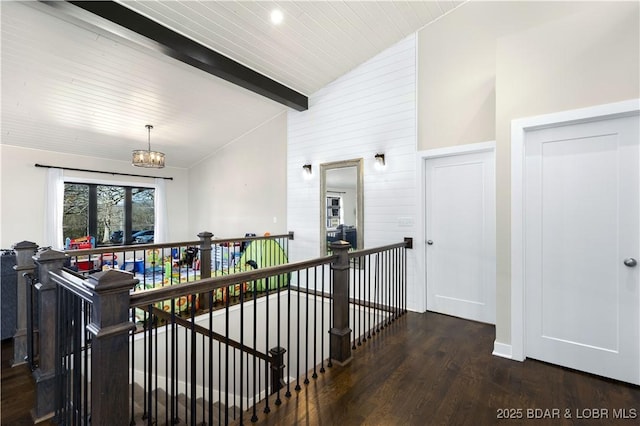 hall with an inviting chandelier, wood finished floors, vaulted ceiling with beams, and an upstairs landing