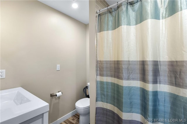 full bath featuring curtained shower, baseboards, toilet, wood finished floors, and vanity