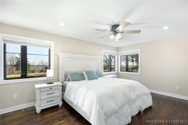 bedroom featuring baseboards, multiple windows, and dark wood-type flooring