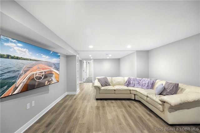 unfurnished living room with recessed lighting, a water view, baseboards, and wood finished floors