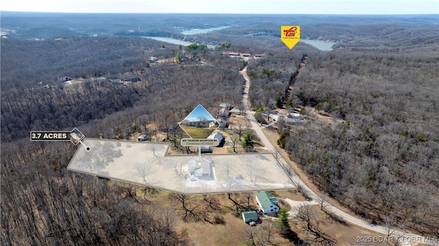 drone / aerial view featuring a wooded view