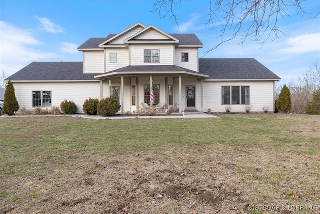 view of front of house with covered porch, roof with shingles, and a front lawn