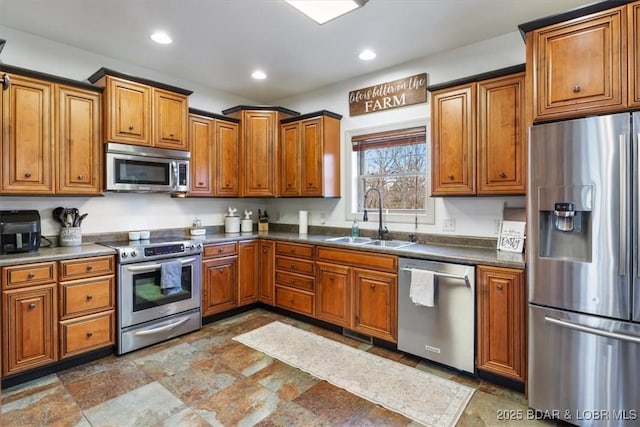 kitchen with stainless steel appliances, recessed lighting, brown cabinetry, and a sink