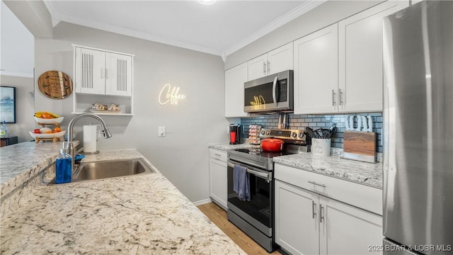 kitchen featuring a sink, tasteful backsplash, white cabinetry, stainless steel appliances, and crown molding