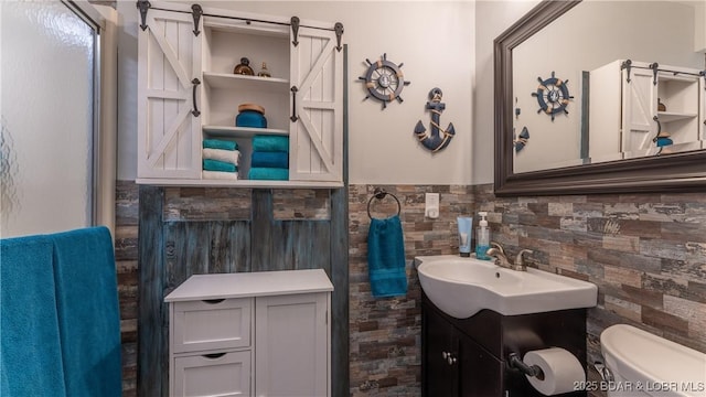 bathroom featuring wainscoting, toilet, and vanity