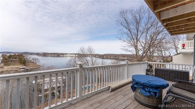 wooden terrace with area for grilling and a water view