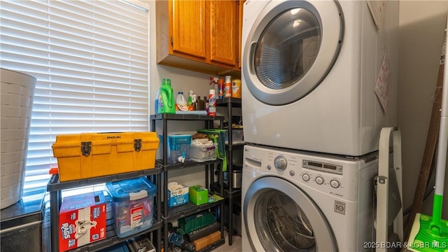 washroom featuring cabinet space and stacked washing maching and dryer