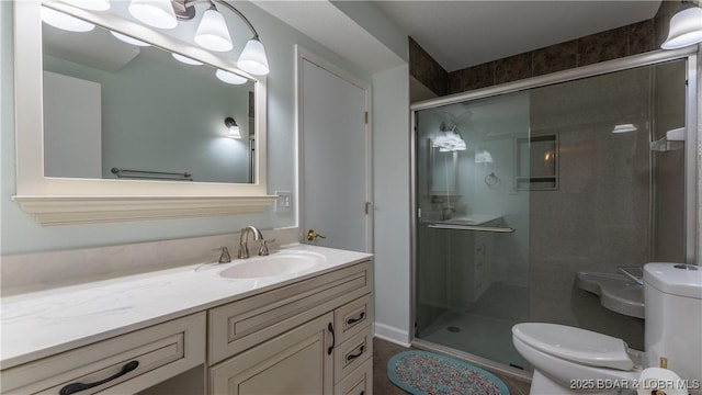 bathroom with a shower stall, vanity, and toilet